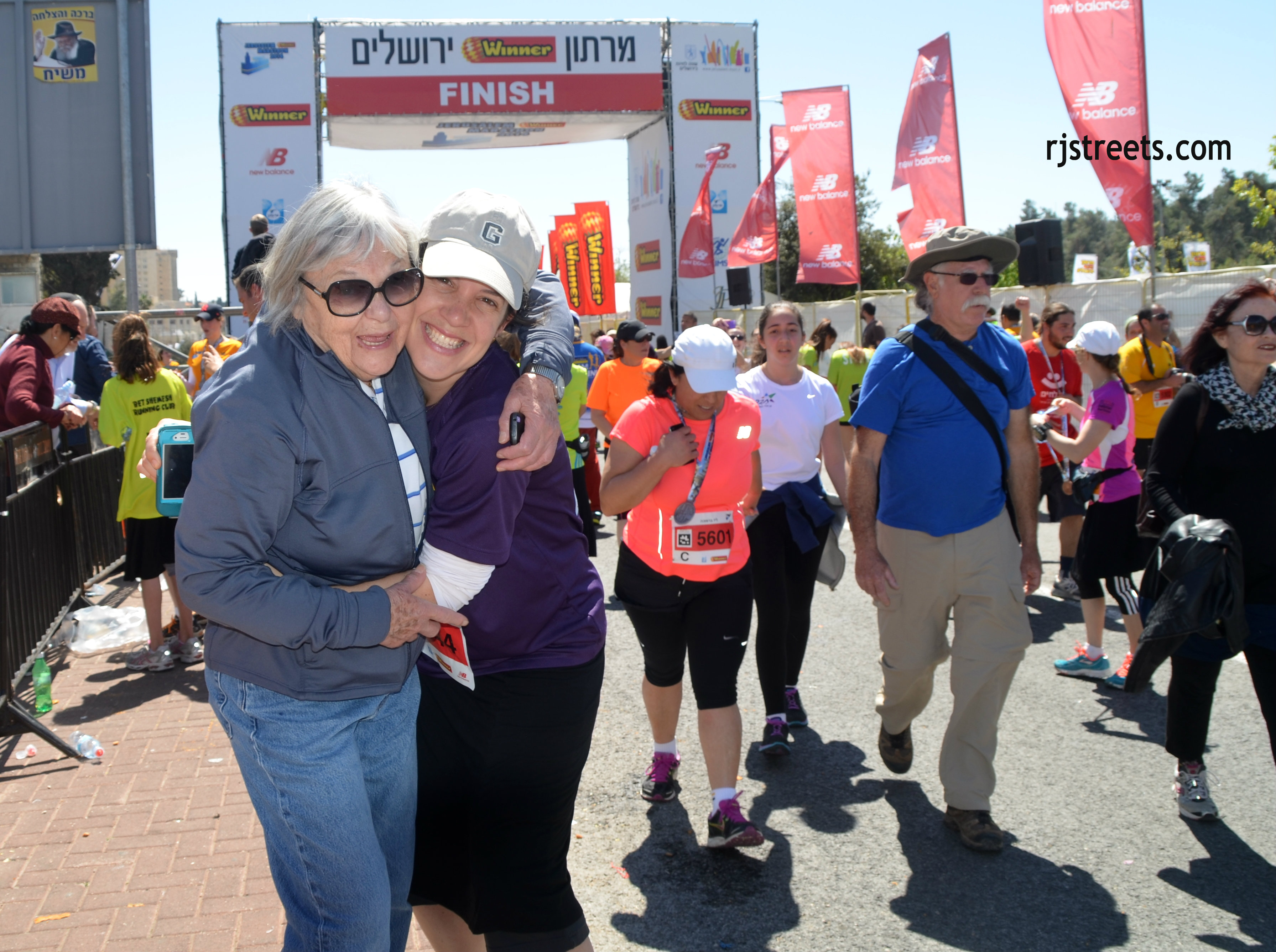 image Jerusalem marathon, photo smiling race finshers, picture grandmother hugging girl at end of race